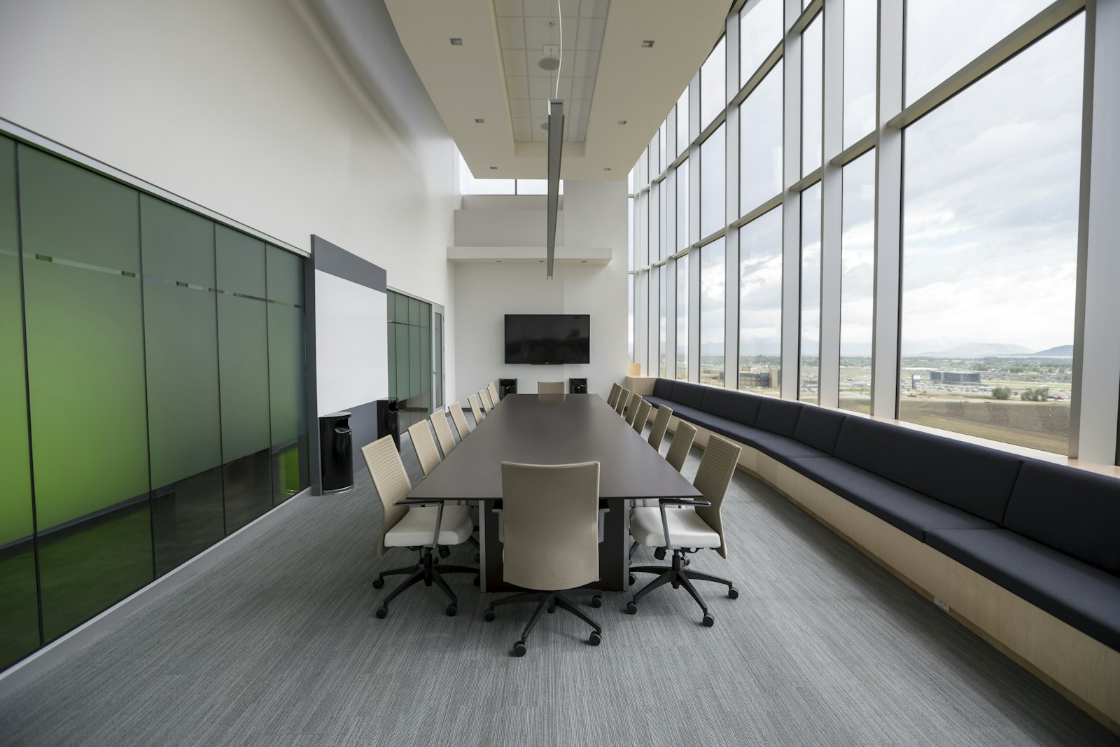 Executive boardroom with a long conference table and floor-to-ceiling windows